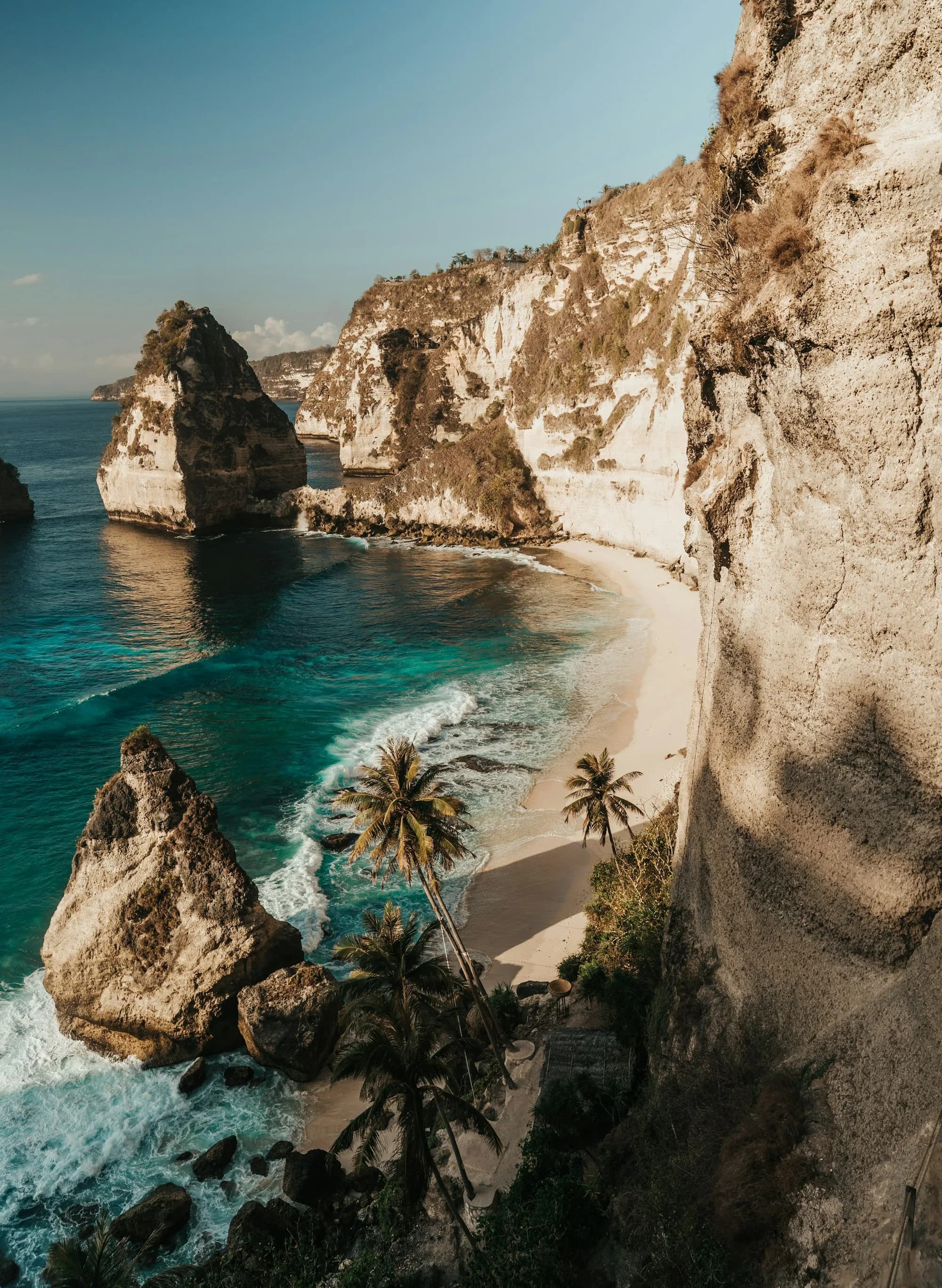 Curved white sand beach far below the cliffs of Nusa Penida